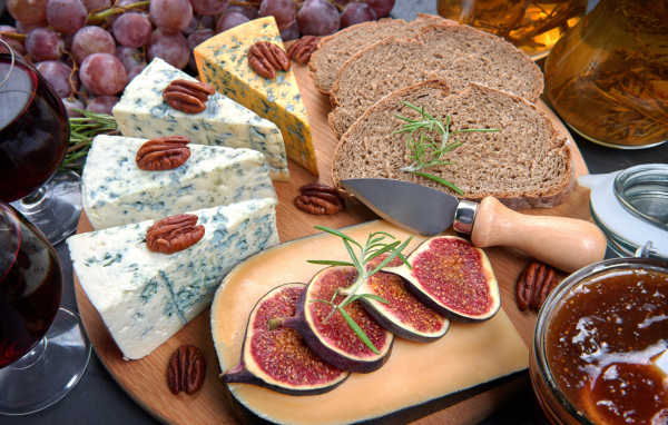Сыр на столе с инжиром и кусками хлеба