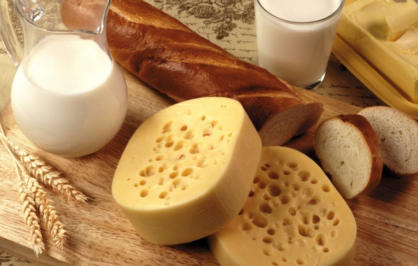 Cheese on the table with butter, milk and loaf  
