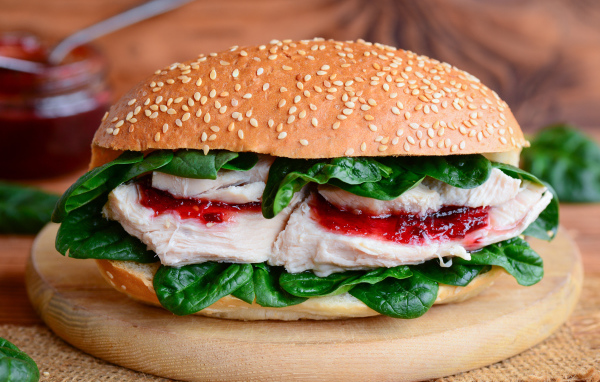 Гамбургер с курицей и зелеными листьями шпината