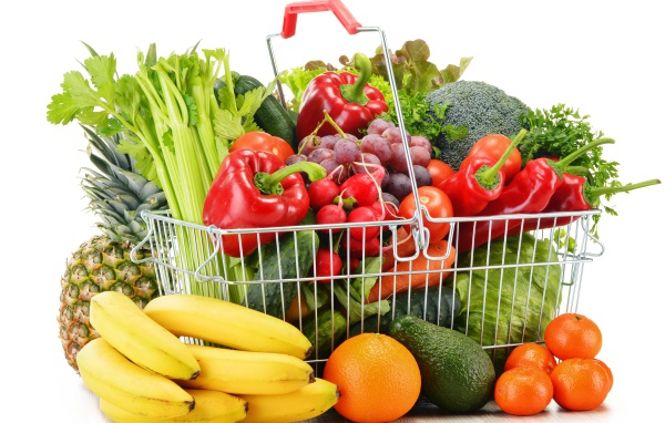 Железная корзина со свежими овощами и фруктами на белом фоне