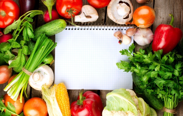 Блокнот со свежими овощами на столе 