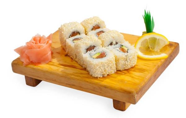 Роллы на деревянной доске с лимоном и имбирем