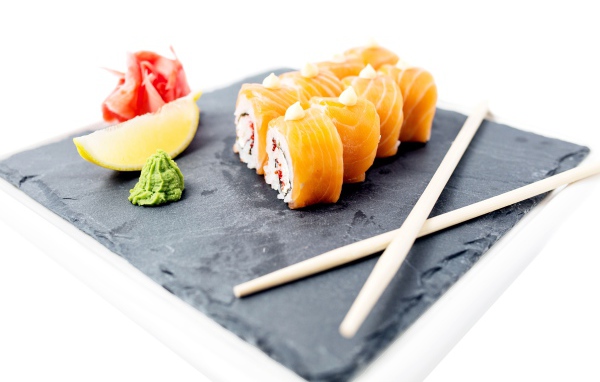 Роллы с красной рыбой на тарелке с палочками