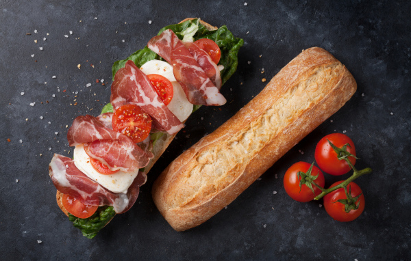 Бутерброд с ветчиной, помидорами, яйцом и листьями салата