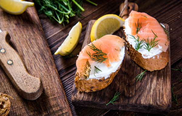 Бутерброды с сыром и красной рыбой на разделочной доске