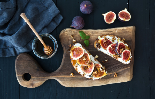 Бутерброды с инжиром на разделочной доске с медом 