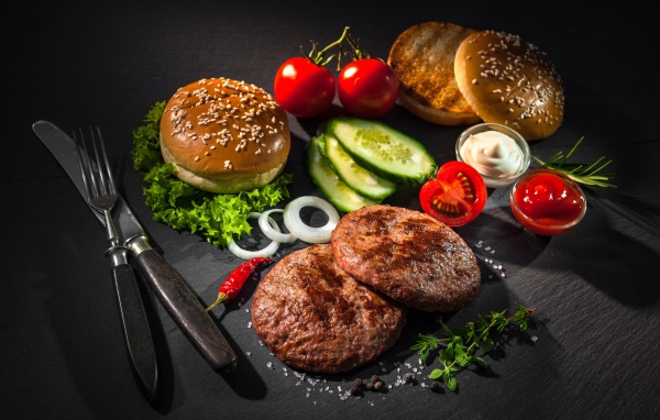 Вкусный натюрморт из гамбургеров на сером фоне
