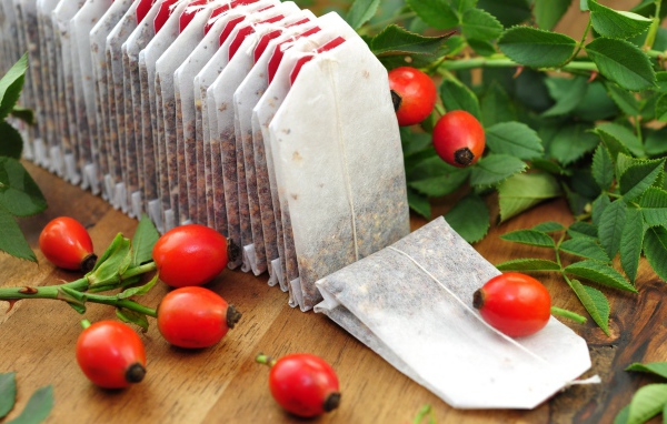 Чай в пакетиках на столе с ягодами шиповника 