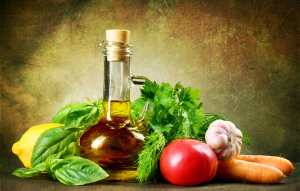 Овощи на столе с  кувшином растительного масла