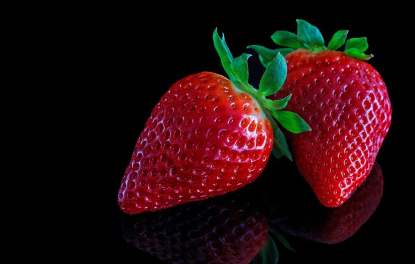 Красивая крупная красная клубника на черном  фоне