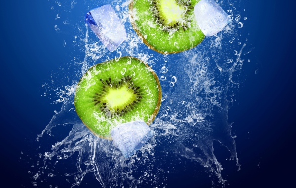 Киви в брызгах воды со льдом на синем фоне