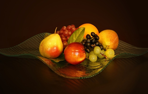 Груши, виноград, нектарин в красивой стеклянной вазе