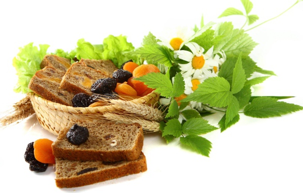 Сухофрукты с хлебом и цветами ромашки на белом фоне