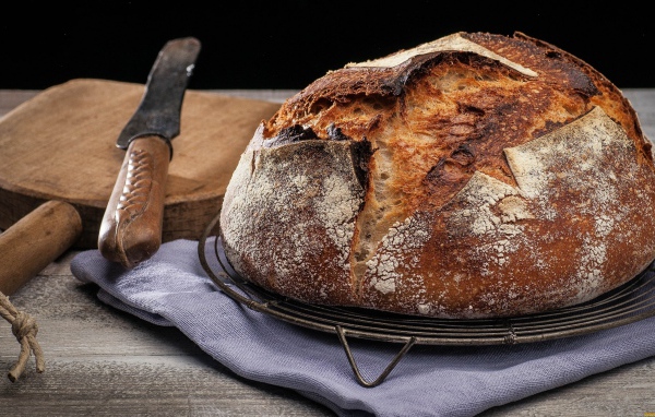 Зажареный круглый хлеб на столе с ножом