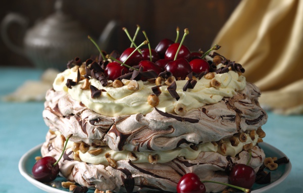 Красивый кремовый торт с шоколадом и ягодами черешни и орехами