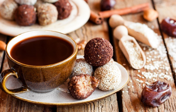 Большая чашка кофе с круглыми аппетитными конфетами