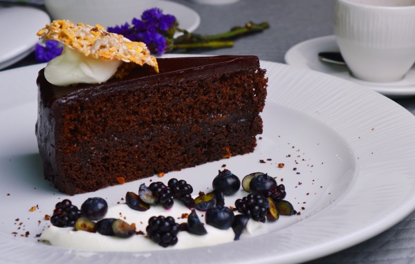 Кусок шоколадного пирога на большой белой тарелке