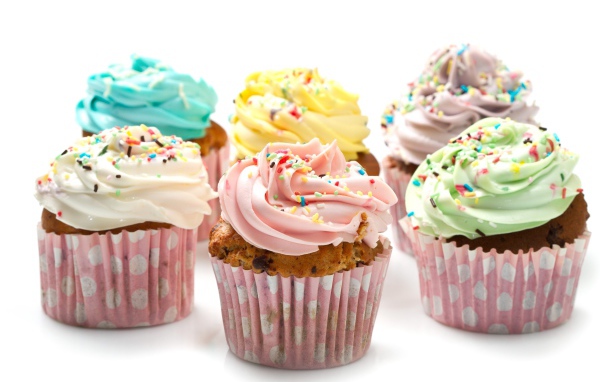 Аппетитные капкейки с кремом на белом фоне