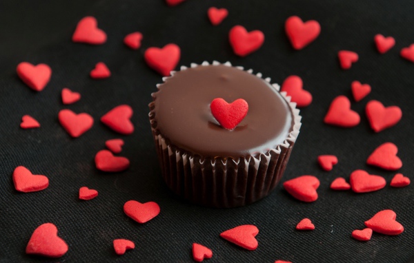 Аппетитный шоколадный кекс украшен маленькими сердечками