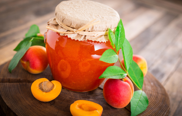 Абрикосовое варенье в банке на столе с абрикосами