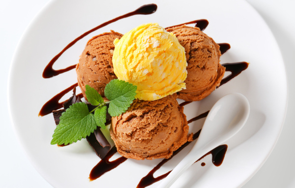 Шарики кофейного и фруктового мороженого на белой тарелке