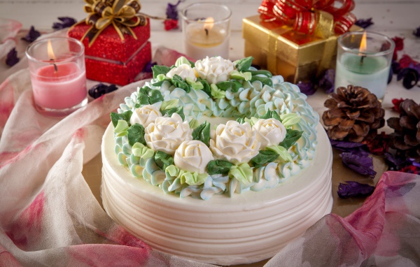 Красивый праздничный торт на столе с подарками и свечами