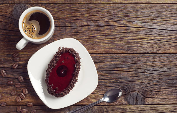 Пирожное с шоколадом на деревянном столе с чашкой кофе