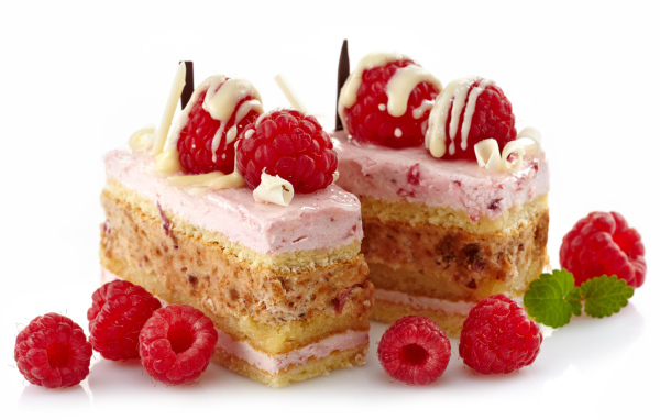 Пирожные с ягодами малины на белом фоне