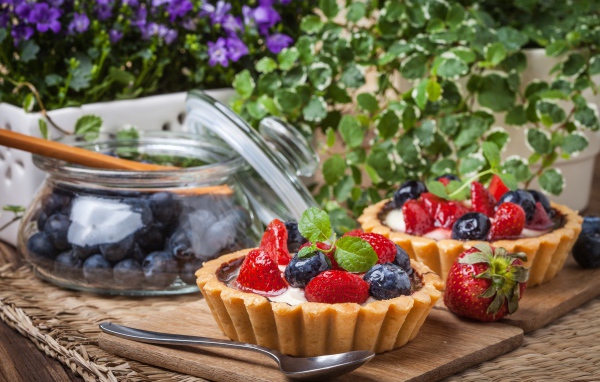 Пирожные с ягодами клубники и черники на столе