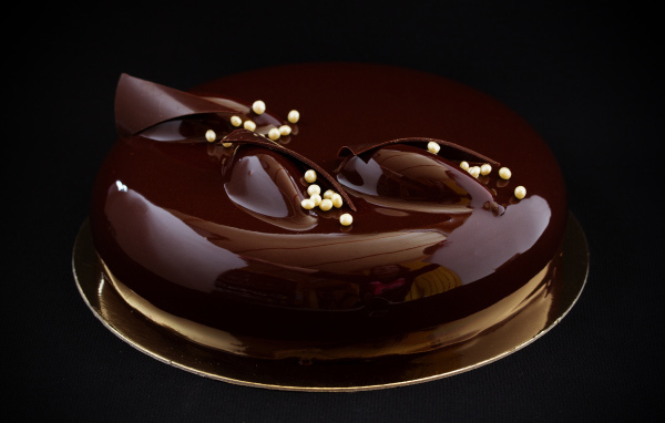 Шоколадный глянцевый торт на черном фоне 