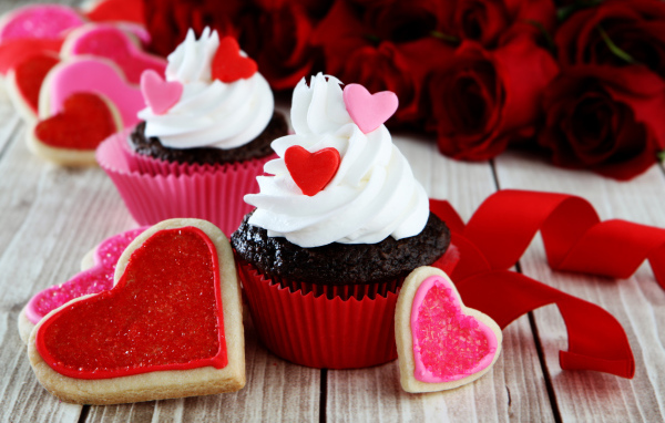 Капкейки с кремом и печенье в форме сердечек на столе