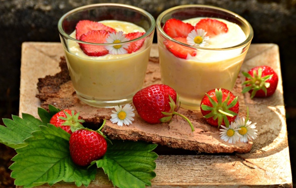 Десерт с йогуртом и свежей клубникой в стаканах на столе