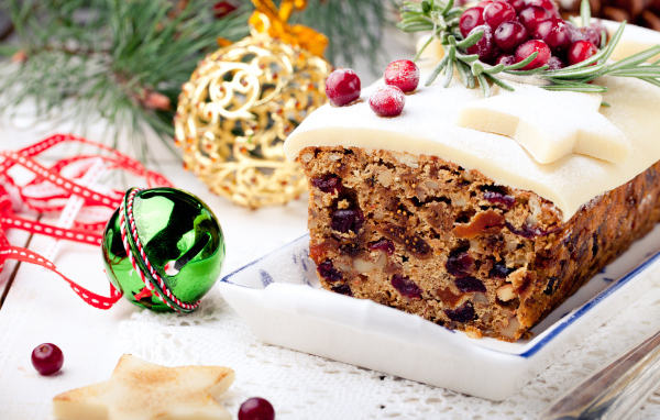 Праздничный новогодний кекс с сухофруктами и игрушками на столе