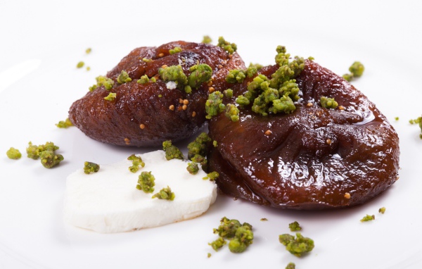 Инжир с фисташковыми орехами на белом фоне