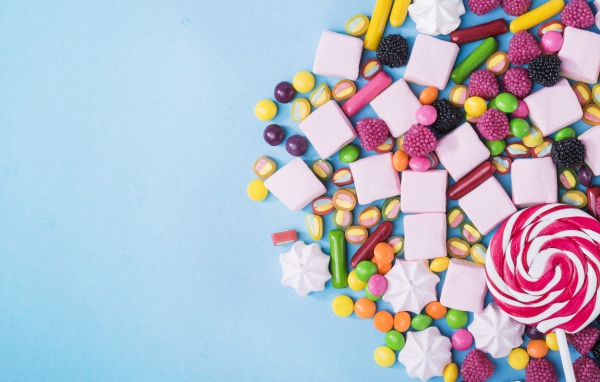 Маршмеллоу, конфеты и желе на голубом фоне