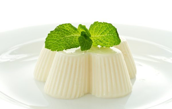 Молочное желе с мятой на белой тарелке 