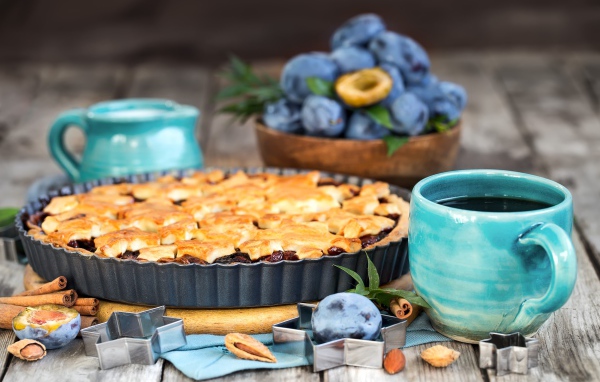 Пирог со сливами и чаем на столе