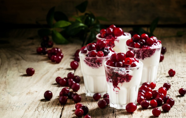 Сладкий десерт с клюквой в стеклянных стаканах