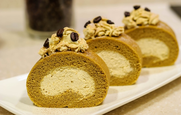 Сладкий рулет с кремом и зернами кофе