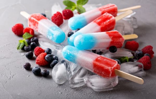 Трехцветное фруктовое мороженое лежит на кусочках льда