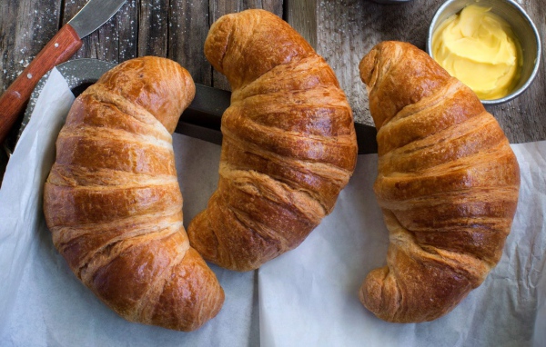 Три свежих круассана на столе с кремом 