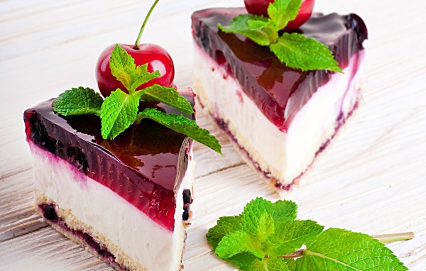 Два аппетитных пирожных с черешней и свежей мятой