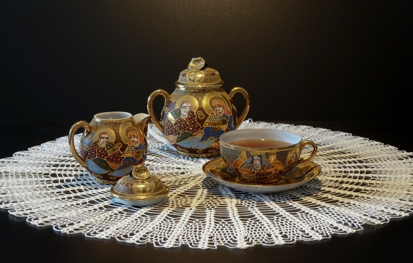 Красивый чайный сервиз на столе с белой салфеткой