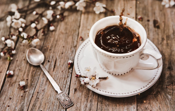 Чашка кофе на столе с цветами абрикоса