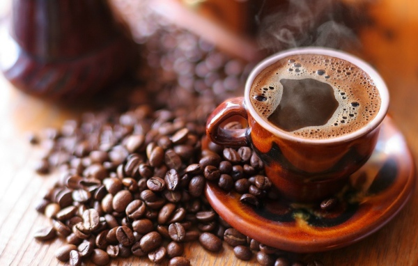 Чашка горячего кофе на столе с кофе 