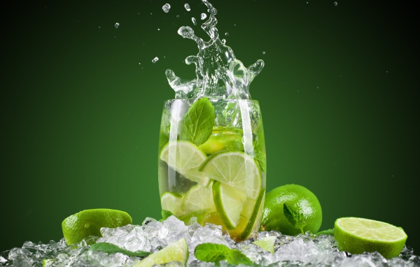 Стакан с лимонадом стоит на кусочках льда с лаймом