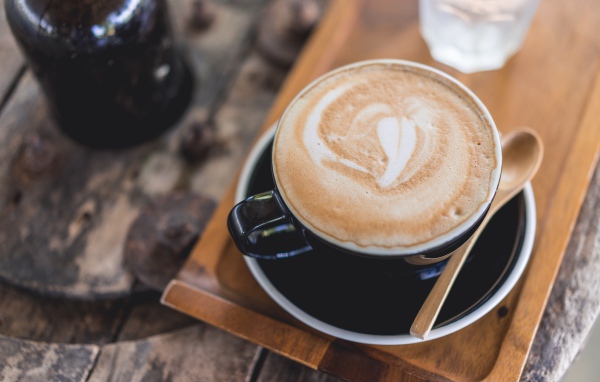 Большая чашка кофе с пеной на столе