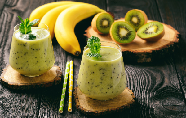 Коктейль с киви и бананами в стаканах на столе