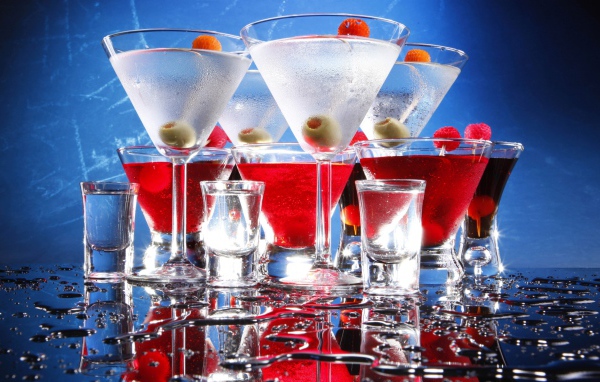 Коктейли с рюмками на мокром столе