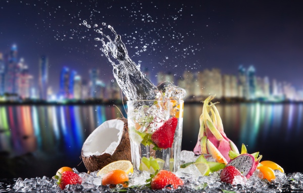 Напиток в стакане с тропическими фруктами на фоне ночного города